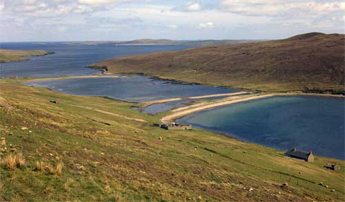 Barriere di spiaggia lunghe e strette connettono le due colline; mentre tra le barriere c' è una laguna. A Shetland, in Gran Bretagna.