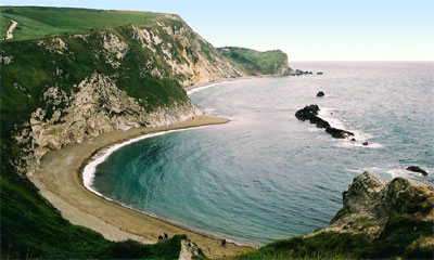 Uma praia se formou no fundo de uma falésia erodida. Man O' War Bay, Dorset, Inglaterra. © Richard Burt